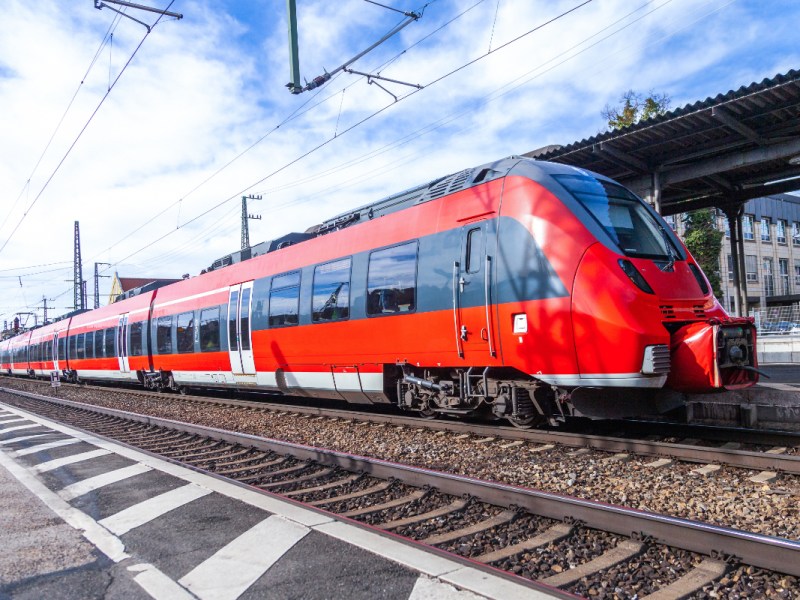 Ein Zug der Deutschen Bahn steht am Gleis an einem Bahnhof.