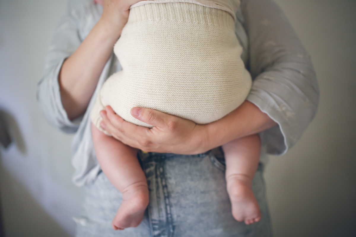 Eine Mutter hält ihr gewickeltes Baby im Arm.